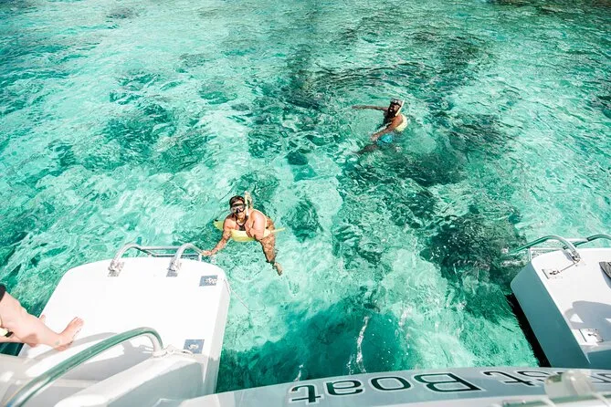 Snorkelers gearing up on a catamaran deck before entering the water for a guided snorkeling in St. John USVI excursion — reef-safe sunscreen, mask and fins ready