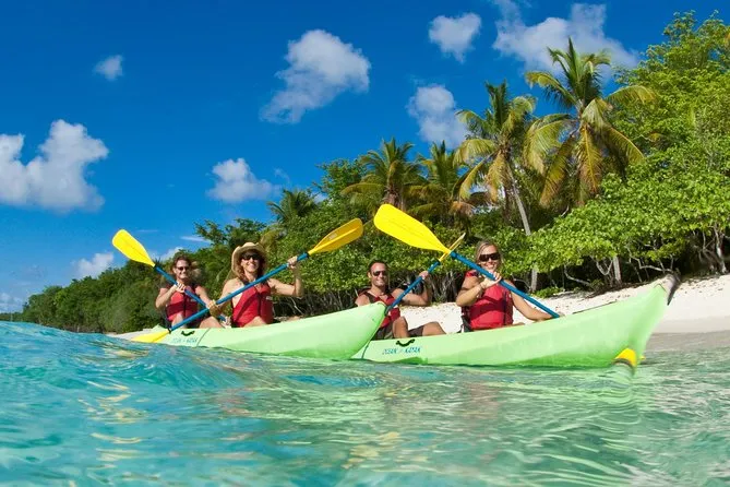 A guided kayak group paddling toward a secluded beach near Honeymoon Beach St. John USVI for a snorkeling excursion in the Virgin Islands National Park protected waters
